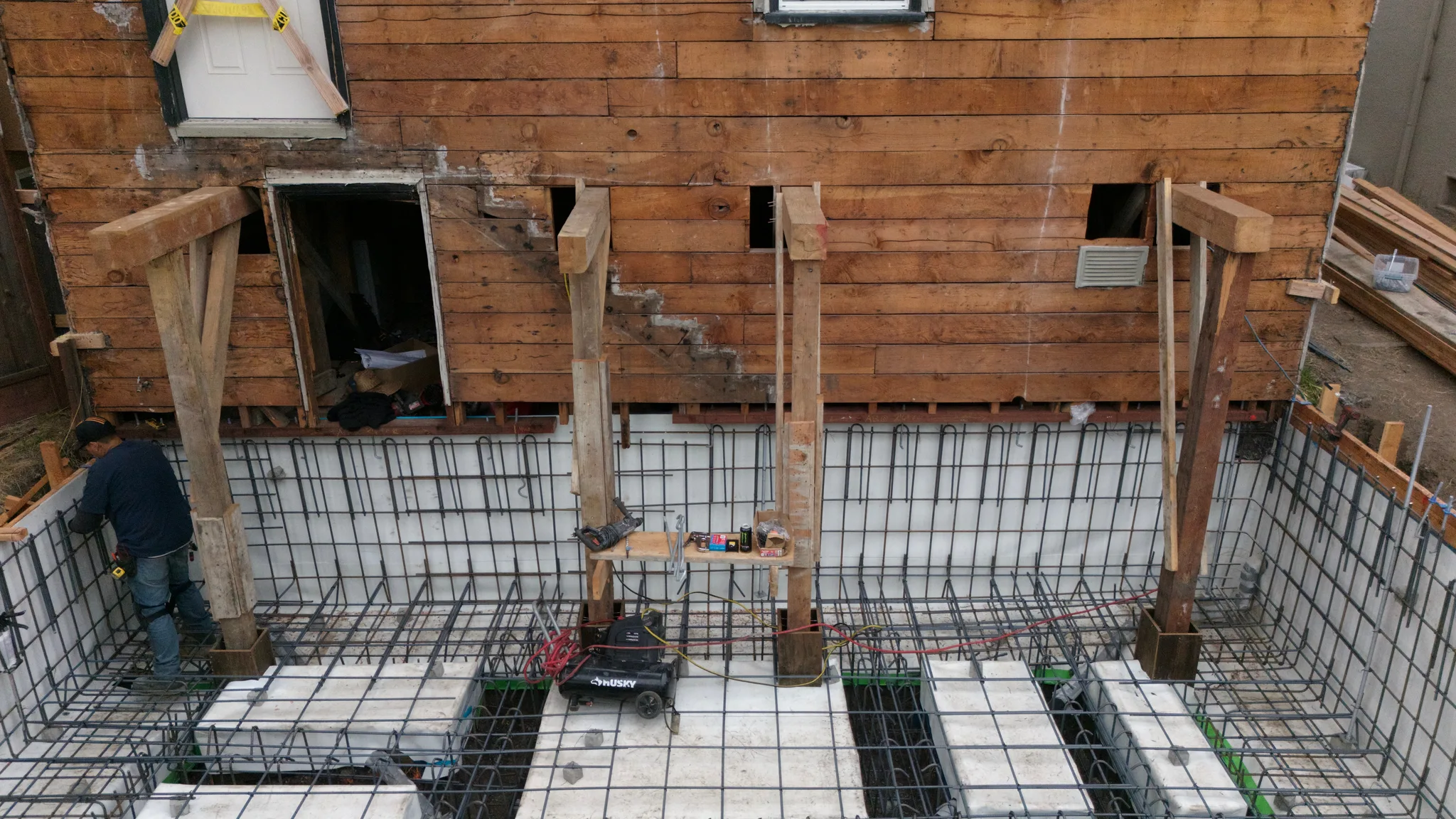 Temporary shoring posts carrying the rear wall above the foundation steel — Albany Home Addition Foundation, Albany, CA