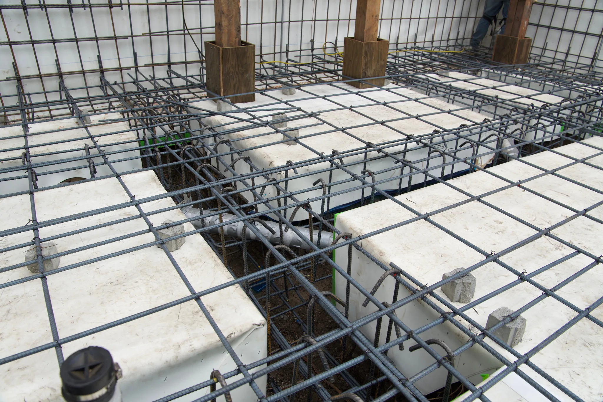 Slab rebar tied over void forms, plumbing sleeved through the grade beams — Albany Home Addition Foundation, Albany, CA