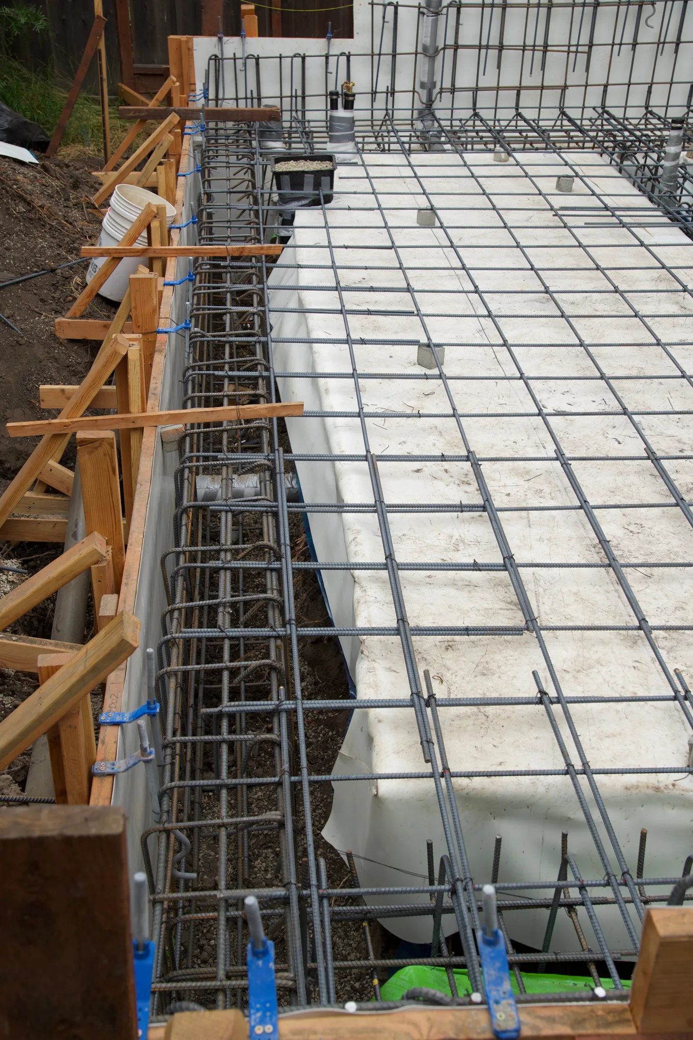 Braced perimeter formwork and wall steel beside the vapor-sealed void forms — Albany Home Addition Foundation, Albany, CA