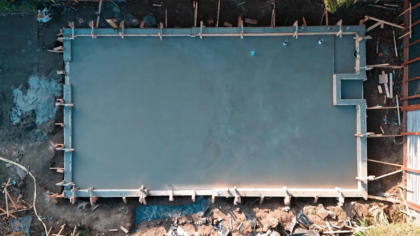 Top-down view of the finished ADU slab still in its forms, anchor bolts set and the stepped bump-out at one corner — Berkeley Backyard Detached ADU, Berkeley, CA