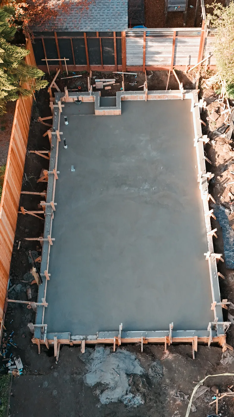 Aerial down the length of the finished slab with the raised stem section at the far corner — Berkeley Backyard Detached ADU, Berkeley, CA