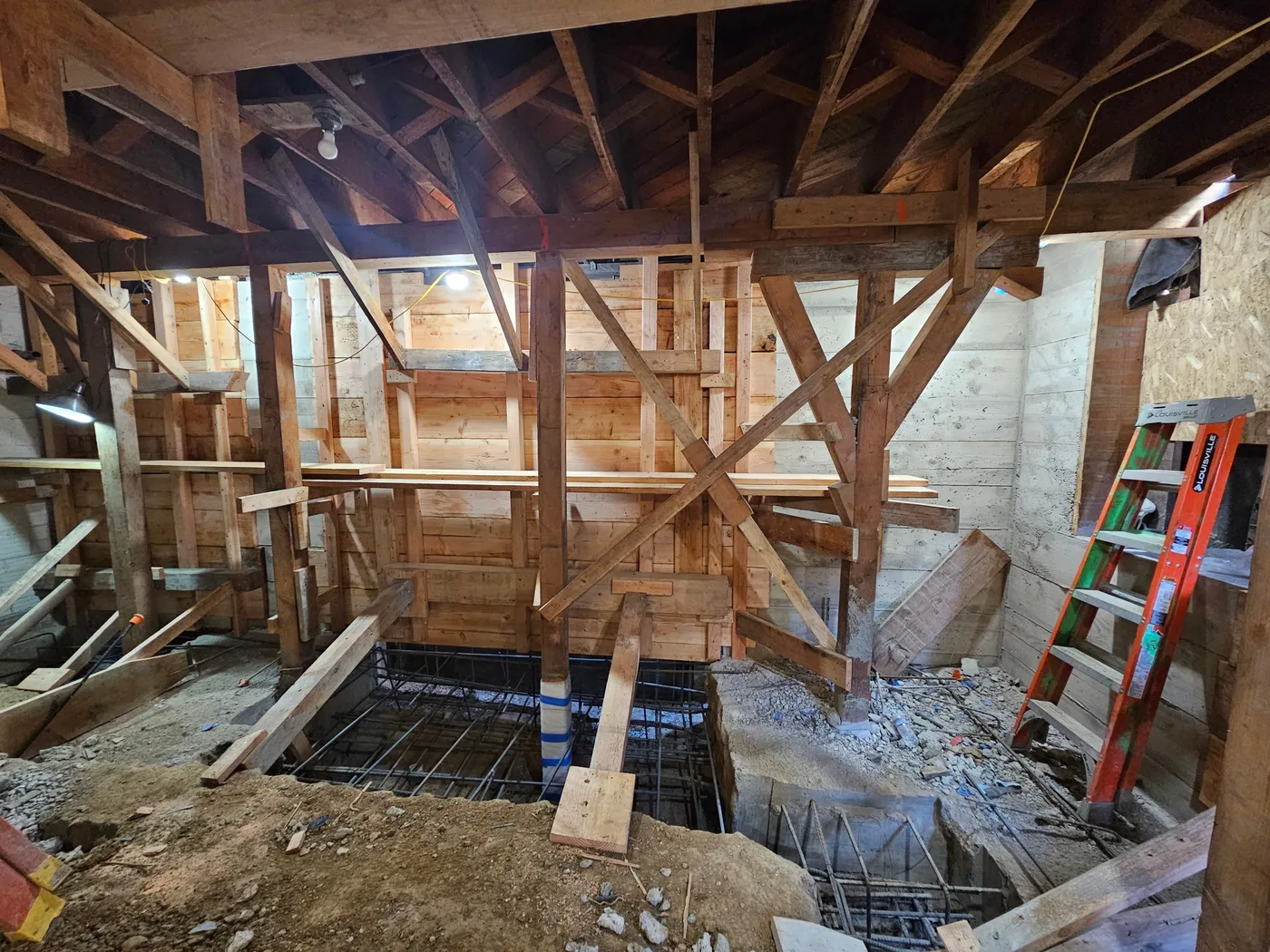 Footing rebar in the excavation with cribbing and bracing overhead — Durant Basement Foundation, Berkeley, CA