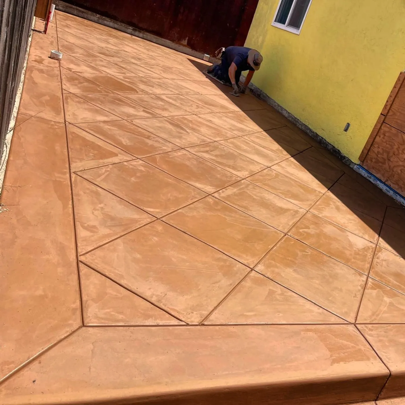 The long Spanish Gold driveway with a diamond score pattern, freshly finished — Oakland Gold Driveway & Patio, Oakland, CA