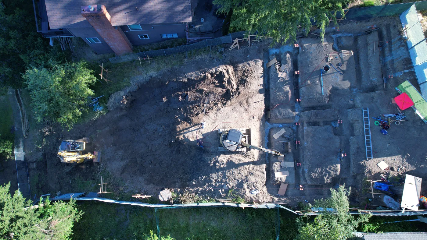 Aerial top-down of the cleared, excavated hillside site — Oakland Hills Custom Home, Oakland, CA