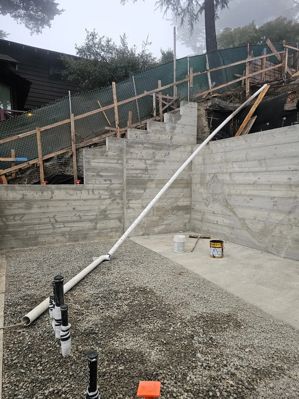 A tall structural retaining wall with its gravel base and drain line — Oakland Hills