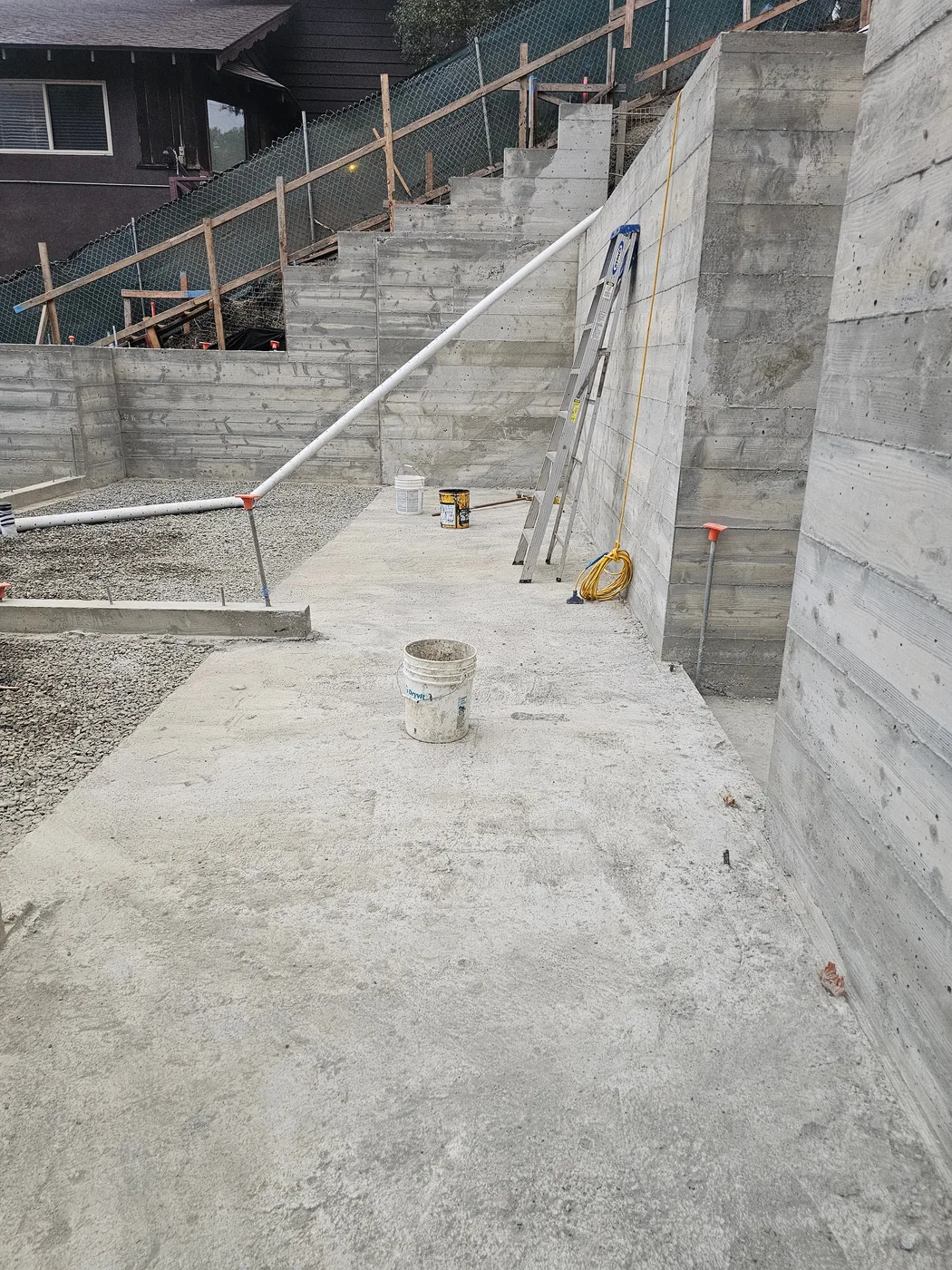 Poured concrete walls and stepped foundation, house behind — Oakland Hills Custom Home, Oakland, CA