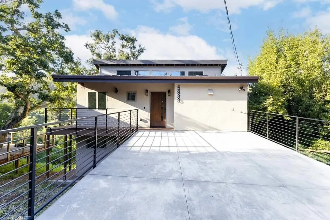 An elevated concrete bridge driveway with steel guardrails, built by New Edge Concrete for a modern hillside home in Richmond, CA