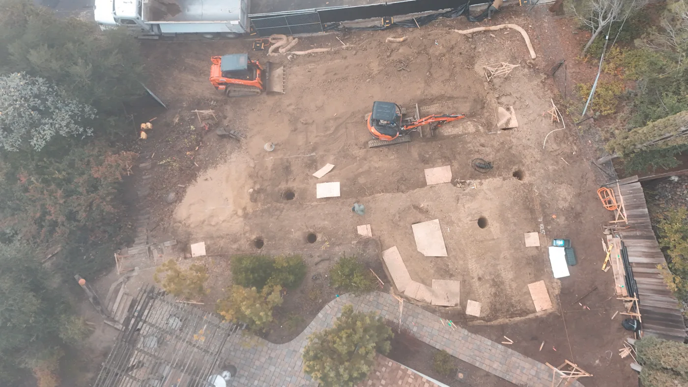 The excavated building pad with drilled pier holes and layout marks across it — Steep Hillside Lafayette ADU, Lafayette, CA