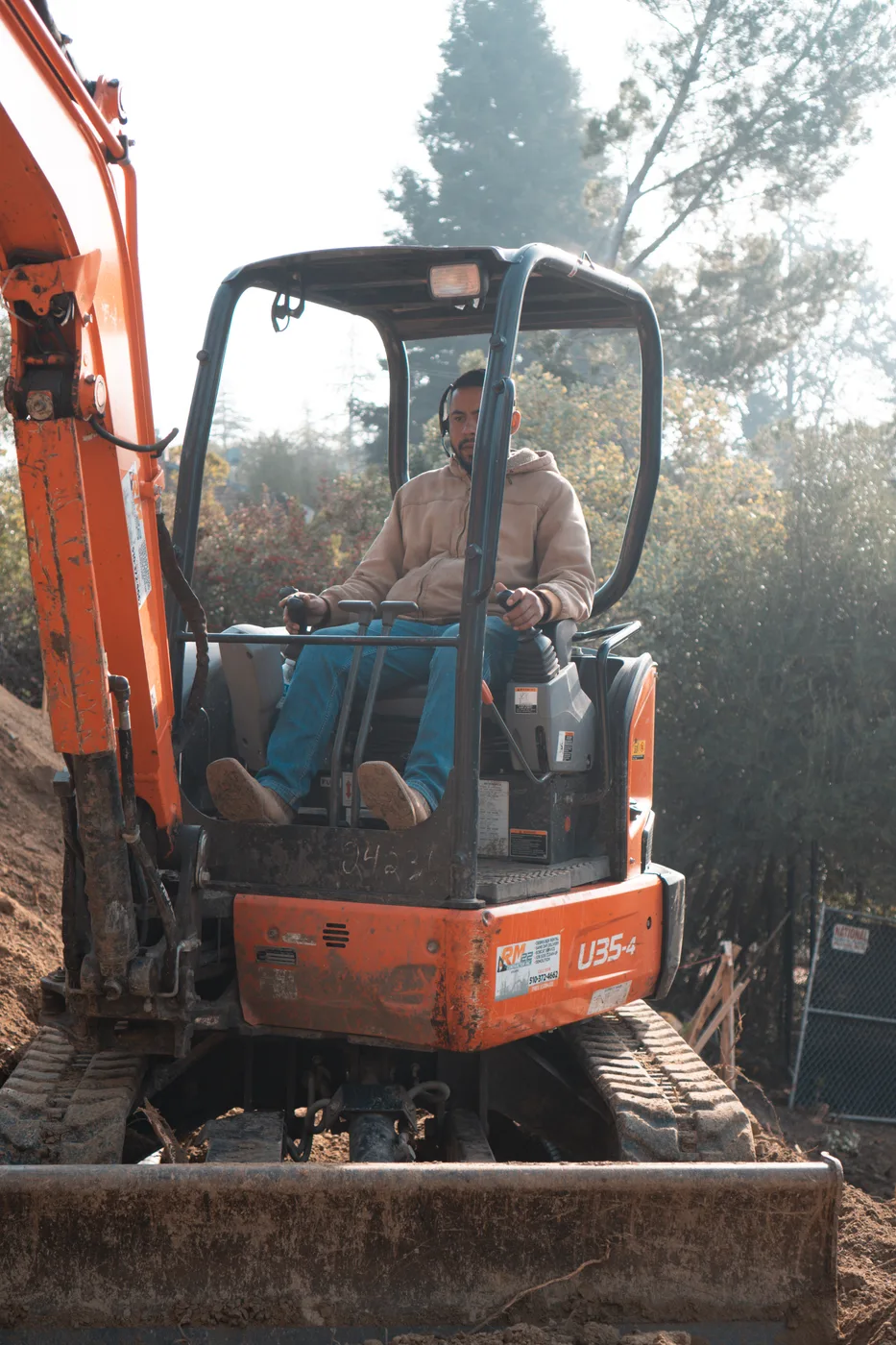 Operator working the mini excavator on the hillside cut — Steep Hillside Lafayette ADU, Lafayette, CA