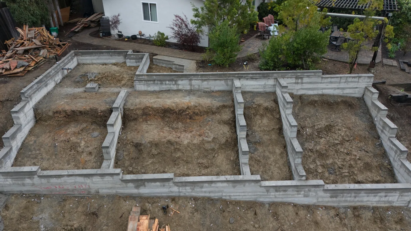 The completed foundation seen from above the slope, perimeter and interior walls dividing the footprint — Steep Hillside Lafayette ADU, Lafayette, CA