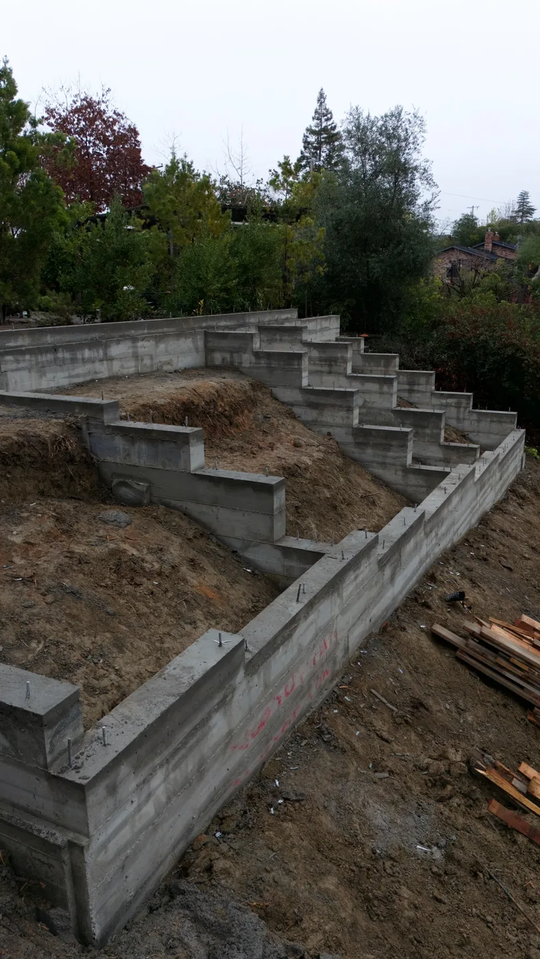 The stepped footings marching down the grade along the length of the foundation — Steep Hillside Lafayette ADU, Lafayette, CA